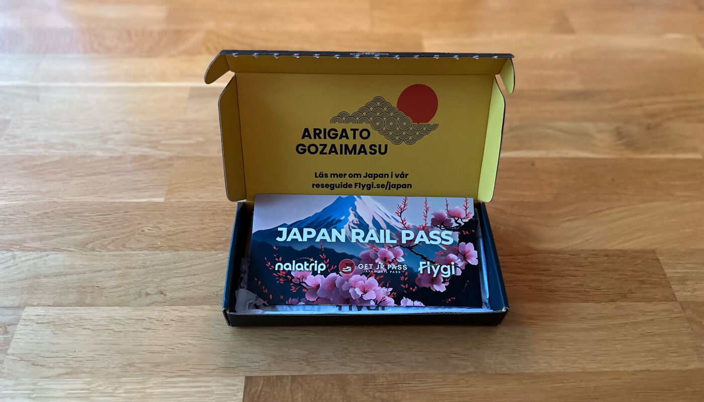 Vacker voucher med texten Japan Rail Pass och Mount Fuji i en gul pappkartong.