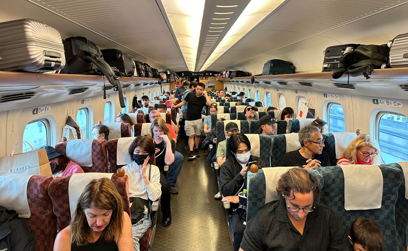 Fullsatt vagn på snabbtåg. I mittgången står flera personer och väntar på lediga platser.